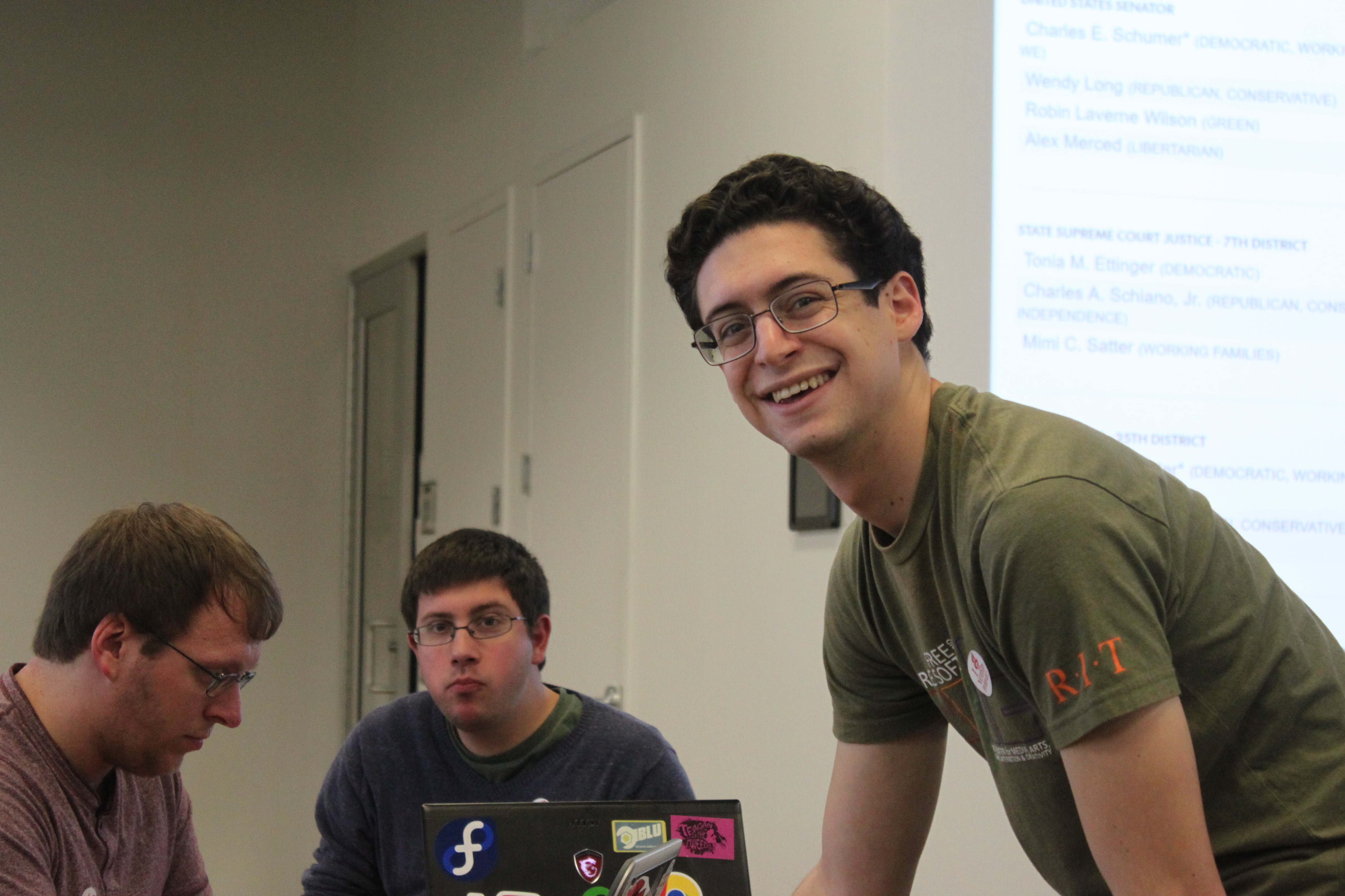 Dan Schneiderman updating the news sources on the projector screens during the Election Night Hackathon by FOSS at RIT