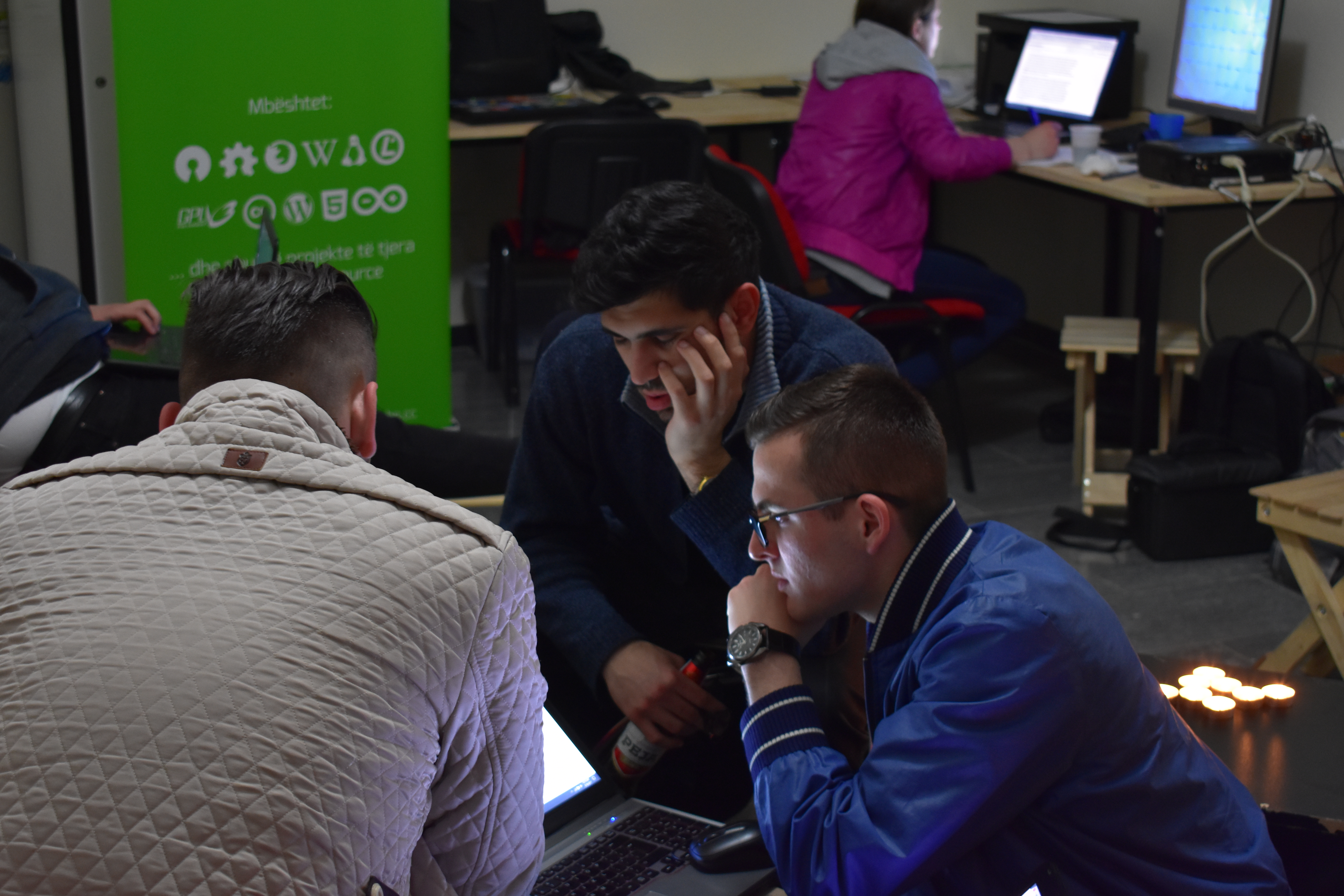 Anxhelo Lushka helps two participants after midnight to help work through some problems in their project