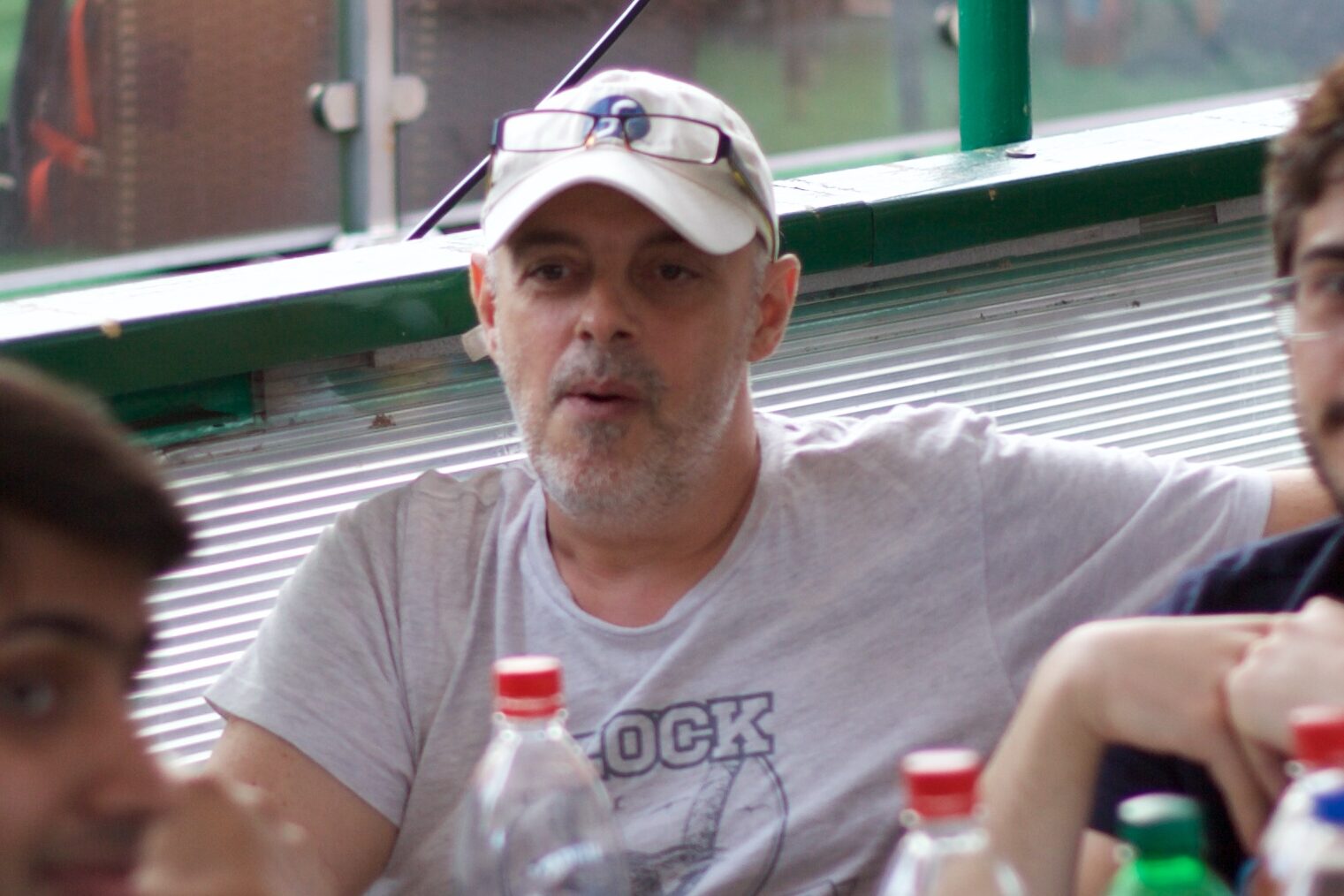 A photograph of Gabriele Trombini at Flock 2016 in Kraków, Poland. Gabriele is seated in a chair around a table, in the middle of two others.